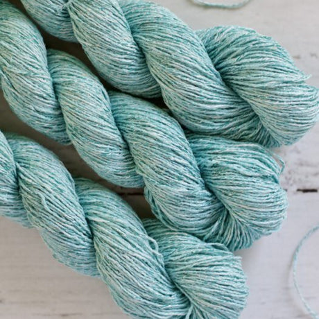 Turquoise yarn skeins on a light wooden surface