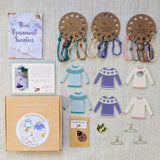 Knitted Mini Ornament Sweaters kit with packaging and materials on a textured surface