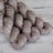 Three skeins of brown yarn on a wooden surface