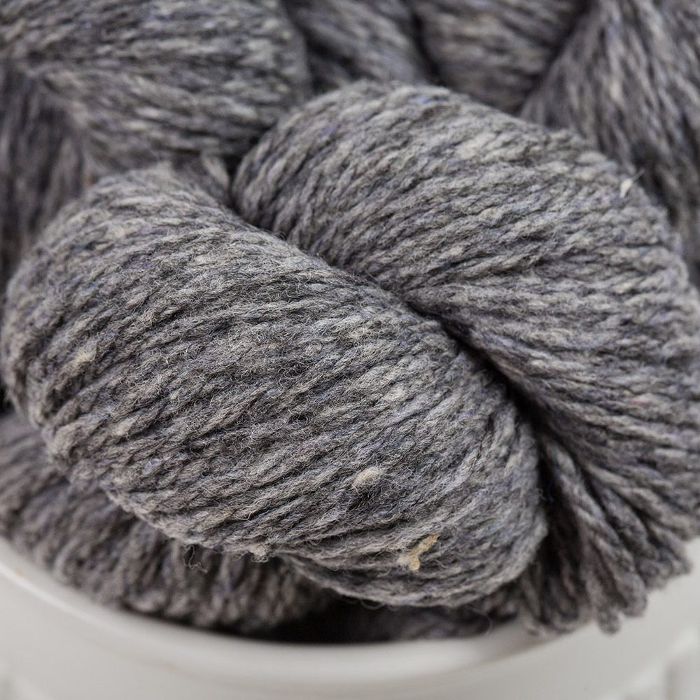 Gray skein of yarn in a white container